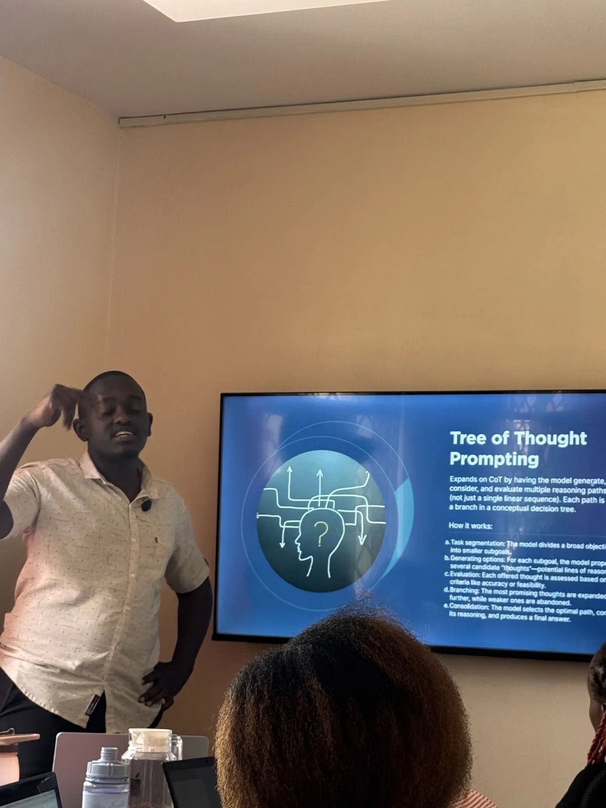 Rodney Maina explaining Tree of Thought prompting to a team