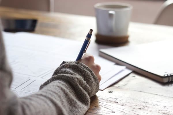 Postgraduate learner planning research notes at a desk